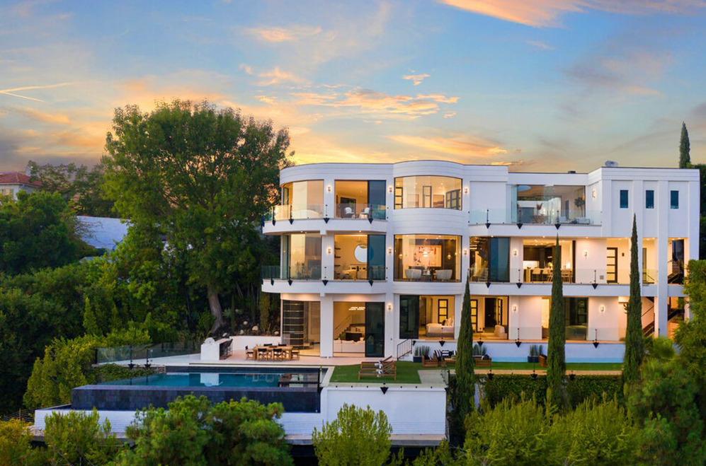 A white modern residence in Beverly Crest at golden hour above a terraced pool