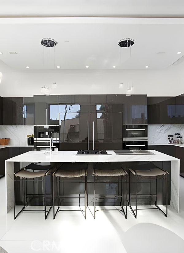 A modern kitchen with a marble island, high-gloss cabinetry, and floor-to-ceiling glass